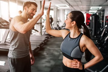 personal trainer giving trainee a high five after a great workout program personal trainer giving trainee a high five after a great workout program